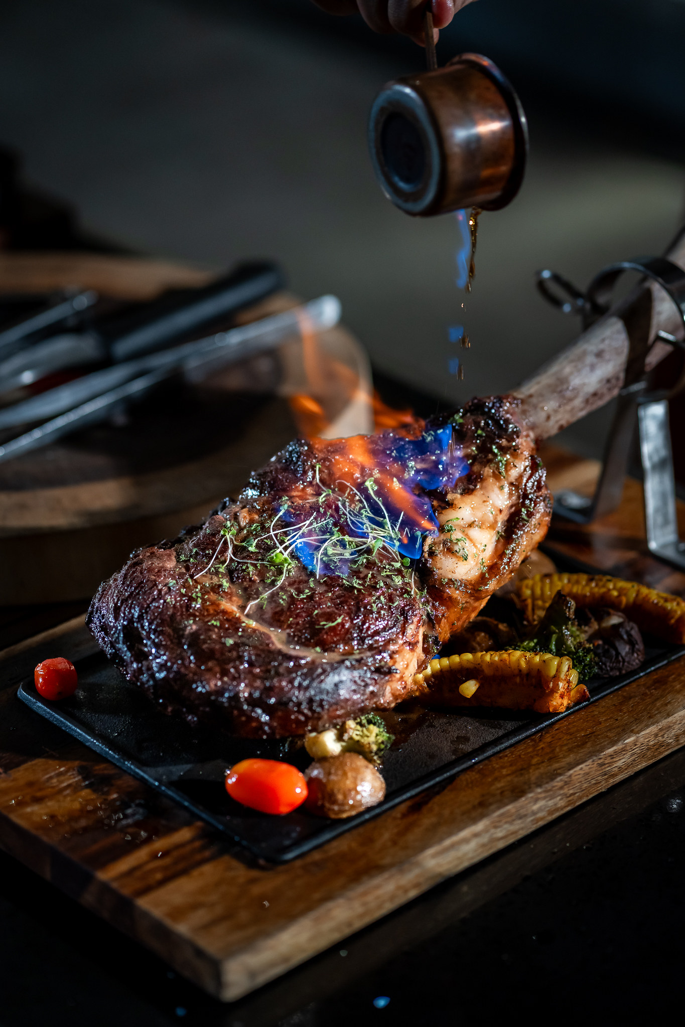 Flaming tomahawk steak served on a board