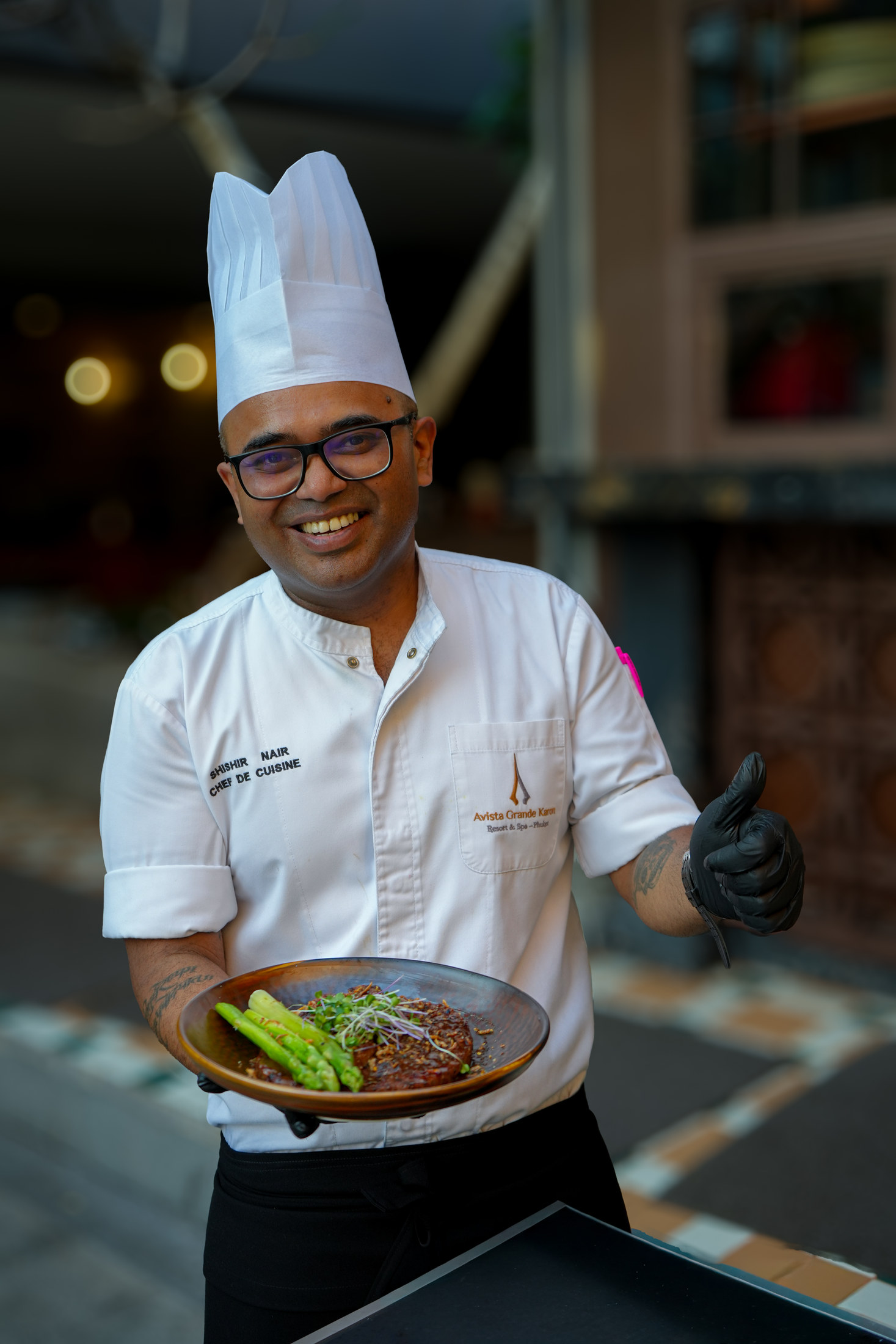 Chef Shishir Nair holding a plated steak