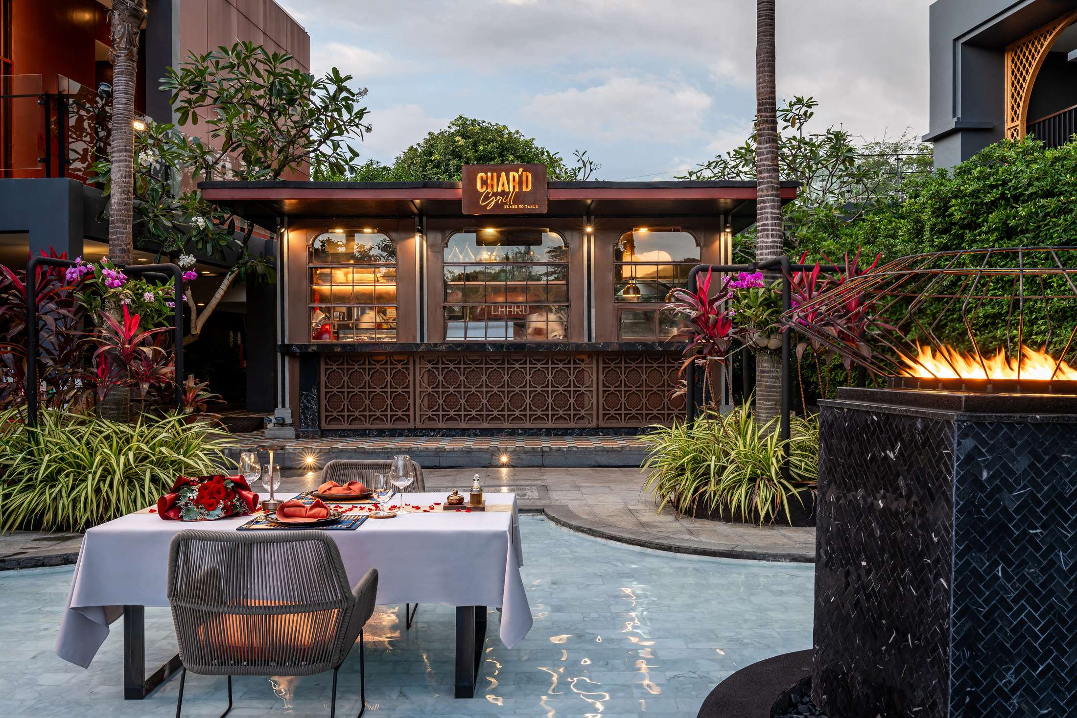 CHAR'D Grill tables set on the water at dusk